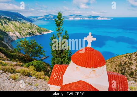 Orangefarbene griechische Heiligtum Proskinitari auf der Klippe mit Defokussierten Meer und cloudscape Sicht in den Hintergrund. Stockfoto