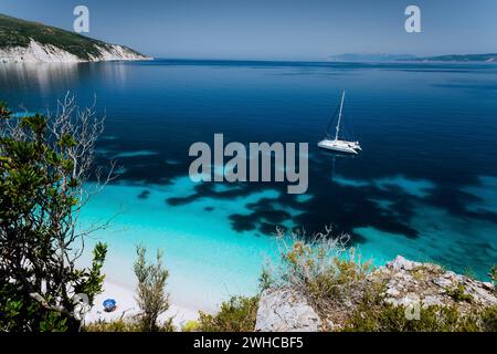 Fteri Strand, Kefalonia Kefalonia, Griechenland. Weißen Katamaran Yacht auf klare transparent blau azurblaue Meer Wasser Oberfläche. Paradise Beach. Stockfoto