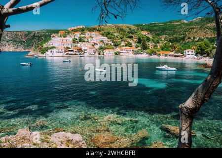 Assos Dorf, Kefalonia Griechenland. Blick auf die türkisfarbene, transparente Bucht Lagune des Mittelmeers. Umgeben von grünen Kiefern. Blaues tiefes Muster auf der Unterseite. Stockfoto