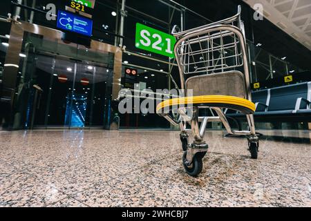 Leerer verlassener Gepäckwagen im geschlossenen Flughafentor aufgrund des weltweiten COVID-19-Ausbruchs des Coronavirus. Stockfoto