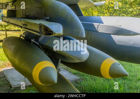 Nahaufnahme-Batterie mit Bomben, die am Seitenflügel des Düsenjägers montiert sind, im öffentlichen Park Stockfoto