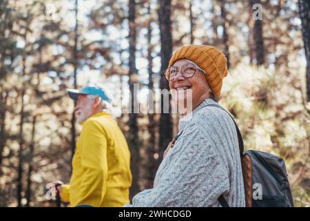 Porträt Nahaufnahme einer fröhlich lächelnden Frau mittleren Alters, die mit ihrem Mann spaziert und Freizeit und Natur genießt. Aktive, schöne Senioren, die zusammen verliebt sind, an sonnigen Tagen. Stockfoto