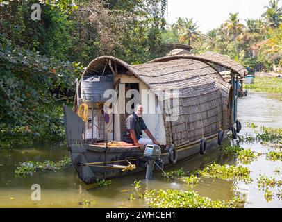 Eine traditionelle Hausboot-Bootstour entlang der Kanäle in der Nähe von Kumarakom bietet eine einzigartige Möglichkeit, die ruhigen Backwaters von Kerala, Indien, zu erkunden Stockfoto