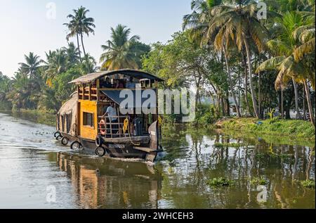 Eine traditionelle Hausboot-Bootstour entlang der Kanäle in der Nähe von Kumarakom bietet eine einzigartige Möglichkeit, die ruhigen Backwaters von Kerala, Indien, zu erkunden Stockfoto