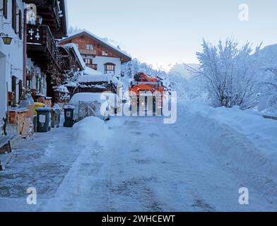 Im Winter in und um Mittenwald räumt der Schneepflug die Straße Stockfoto