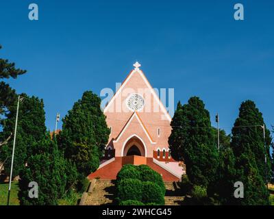 Domaine de Marie Kirche Diözese auf blauem Himmel Hintergrund, versteckt hinter Tannenzweigen am sonnigen Tag, befindet sich in da Lat, Provinz Lam Dong, Vietnam. Stockfoto