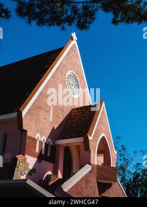 Domaine de Marie Kirche Diözese auf blauem Himmel Hintergrund, versteckt hinter Tannenzweigen am sonnigen Tag, befindet sich in da Lat, Provinz Lam Dong, Vietnam. Stockfoto