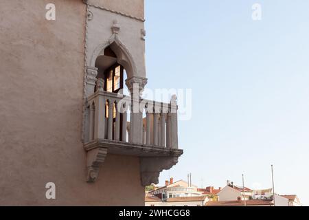 Venezianisches Haus. Venezianische gotische Architektur, Mitte des 15. Jahrhunderts, Fenster mit drei Lanzetten, Eckbalkon mit Steinbalustrade, Tartini-Platz, Piran, S Stockfoto