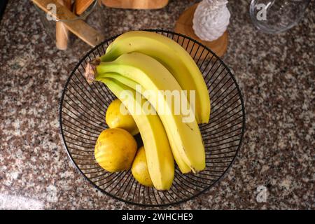 Korb mit köstlichen Früchten auf dem Tisch in der Küche, dekorative Kücheneinrichtung. Stockfoto