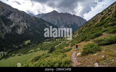 Bergsteiger auf Wanderwegen im grünen Bergtal mit Fluss und steilen Berggipfeln, Chong Kyzyl Suu Valley, Terskey Ala Too, Tien-Shan Stockfoto