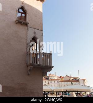 Venezianisches Haus. Venezianische gotische Architektur, Mitte des 15. Jahrhunderts, Fenster mit drei Lanzetten, Eckbalkon mit Steinbalustrade, Tartini-Platz, Piran, S Stockfoto