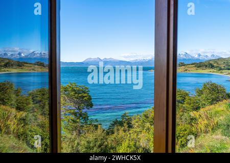 Reflexion in einem Fenster: Blick über den Beagle-Kanal auf die Berge von Hoste Island Chile, Ushuaia, Tierra del Fuego Island, Patagonien, Argentinien Stockfoto