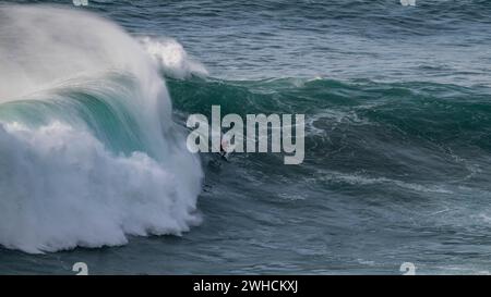 Ein Surfer reitet auf einer stürzenden Welle, Nazare, Portugal Stockfoto