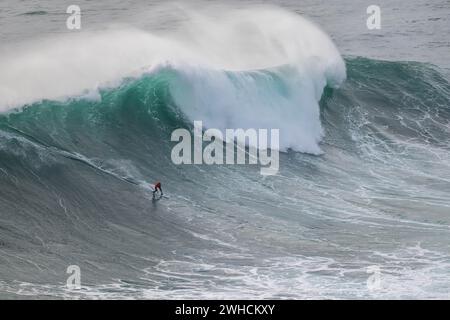 Ein Surfer reitet auf einer stürzenden Welle, Nazare, Portugal Stockfoto