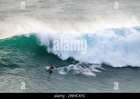 Ein Surfer reitet auf einer stürzenden Welle, Nazare, Portugal Stockfoto