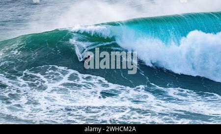 Ein Surfer reitet auf einer stürzenden Welle, Nazare, Portugal Stockfoto