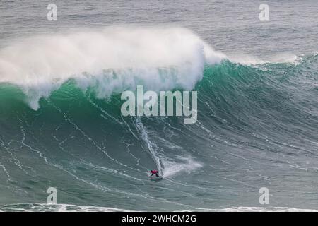 Ein Surfer reitet auf einer stürzenden Welle, Nazare, Portugal Stockfoto