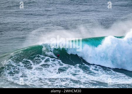 Ein Surfer reitet auf einer stürzenden Welle, Nazare, Portugal Stockfoto