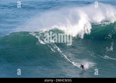 Ein Surfer reitet auf einer stürzenden Welle, Nazare, Portugal Stockfoto