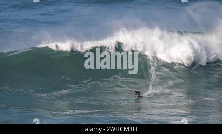 Ein Surfer reitet auf einer stürzenden Welle, Nazare, Portugal Stockfoto