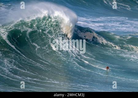 Ein Surfer reitet auf einer stürzenden Welle, Nazare, Portugal Stockfoto