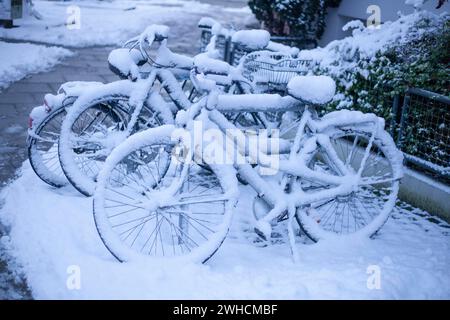 Schneebedeckte Fahrräder an einem Fahrradstand im Winter, Bremen, Deutschland Stockfoto