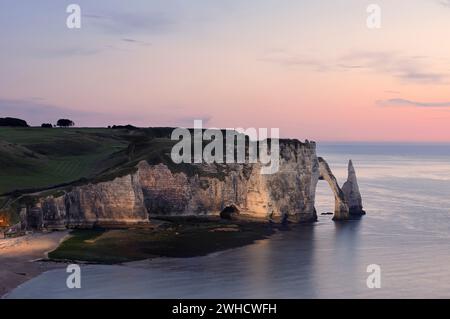 Steile Klippen mit dem Falaise d'Aval Felsentor und der Aiguille díEtretat Felsnadel in der Abenddämmerung, Etretat, Alabasterküste, seine-Maritime, Normandie, Frankreich Stockfoto