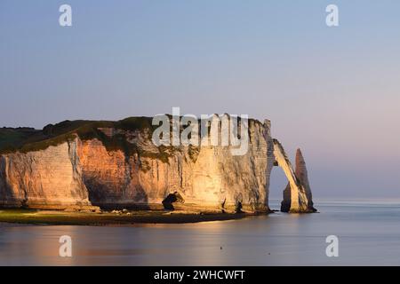 Steile Klippen mit dem Falaise d'Aval Felsentor und der Aiguille díEtretat Felsnadel in der Abenddämmerung, Etretat, Alabasterküste, seine-Maritime, Normandie, Frankreich Stockfoto