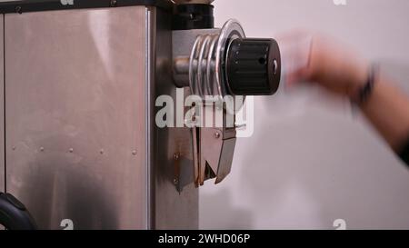 Hand eines Barista, der Kaffee aus einer Kaffeemühle extrahiert. Stockfoto