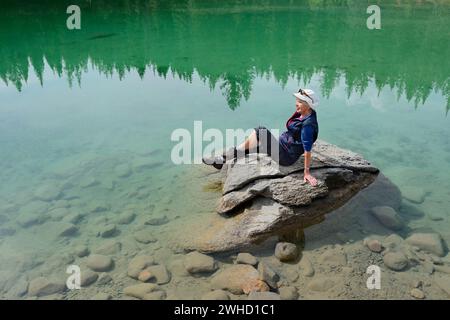 Wanderer, die auf einem Felsen im See ruhen, Valley of Five Lakes, Jasper National Park, Alberta, Kanada Stockfoto