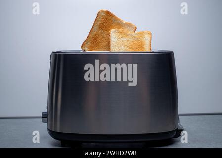 Moderner Toaster mit knusprigen Brotscheiben, Nahaufnahme Stockfoto