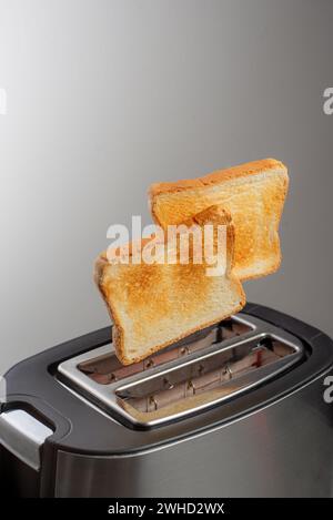 Moderner Toaster mit knusprigen Brotscheiben, Nahaufnahme Stockfoto
