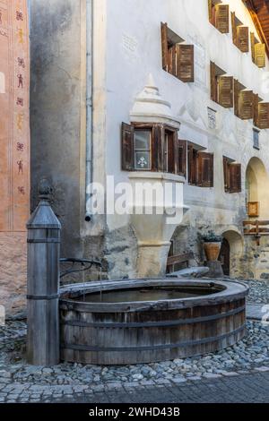 Holzbrunnen, Haus mit Sgraffito, Fassadendekorationen, historische Häuser, Guarda, Engadin, Graubünden, Schweiz Stockfoto