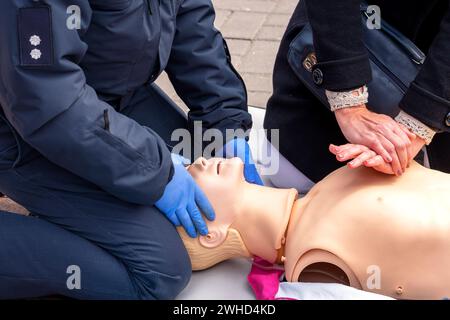 Hände eines Polizisten an einer Schaufensterpuppe während einer Reanimationsübung. HLW-erste-Hilfe-Schulungskonzept.Notfallversorgung. Stockfoto