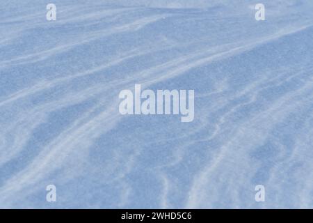 Schnee nach dem Wind bildet eine weiße Leinwand aus wirbelnden Mustern. Leicht, funkelnd, mit Eiskristallen. Eine einzigartige natürliche Textur und die Ruhe des Th Stockfoto