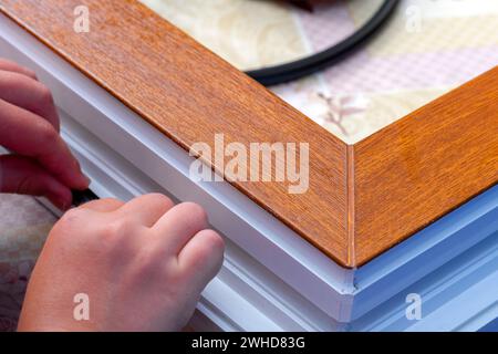 Hände, die Gummistreifen auftragen. Konzeptverbesserung der Abdichtung, Schalldämmung, Wärmedämmung von Fenstern und Türen. Professionelle Versiegelung eines Fensters Stockfoto