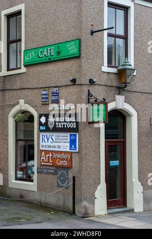 An der Ecke eines traditionellen viktorianischen Gebäudes in einer kleinen Marktstadt gibt es zahlreiche alte und neue Geschäftszeichen Stockfoto