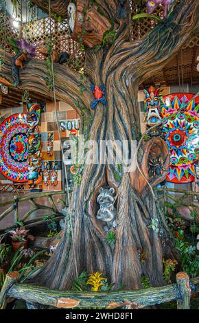 Costa Rica, San Jeronimo - 22. Juli, 20.23: El Jardin Souvenir Shop. Nahaufnahme der dekorierten Holzbaumstatue mit Bildern von Tieren und Vögeln, Backgrou Stockfoto