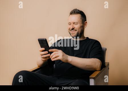 Porträt eines lächelnden Reifen Mannes, der auf beigefarbenem Hintergrund steht. Stockfoto