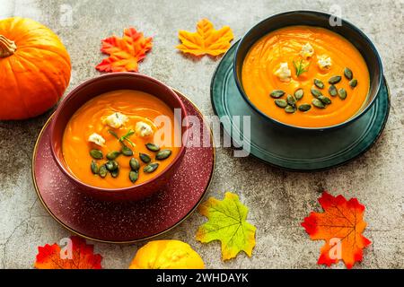 Diät-Kürbissuppe in einer blauen Schüssel auf grauem Hintergrund Stockfoto