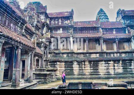 SIEM Reap, Camboda, 3. Juli 2019 - Ein Tourist hält an, um über die Architektur im inneren Quadrankel des Angkor Wat Tempels nachzudenken Stockfoto