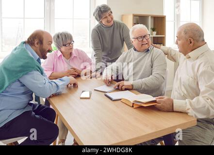 Gruppe fröhlicher älterer Menschen interagieren in modernen Pflegeheimen miteinander. Stockfoto