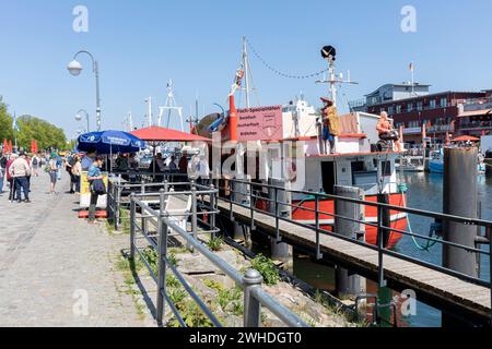 Blick über die Promenade am Alten Strom für Touristen, Fischerboot mit frittierten Fischbrötchen in Warnemünde, Hansestadt Rostock, Ostseeküste, Mecklenburg-Vorpommern, Deutschland, Europa Stockfoto