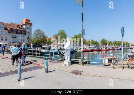 Die weiße Mannstatue auf der Hängebrücke am Alten Strom ist eine Touristenattraktion in Warnemünde, Hansestadt Rostock, Ostseeküste, Mecklenburg-Vorpommern, Deutschland, Europa Stockfoto