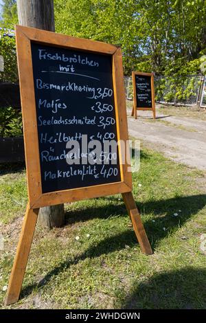 Holzbrett mit Essensangebot Fischbrötchen Matjes Heilbutt Bismark Hering Saithe auf dem Weg zur Ostseeküste, Mecklenburg-Vorpommern, Deutschland, Europa Stockfoto