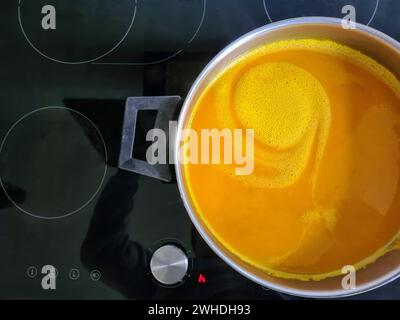 Hausgemachte frische Kürbissuppe in einem Topf auf dem Kochfeld Stockfoto