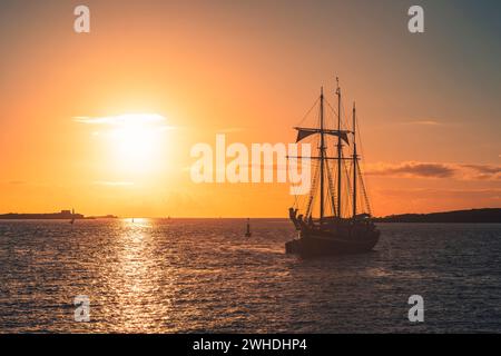 Ein drei-Meister liegt vor der französischen Westküste in der Bretagne bei Sonnenuntergang, warmen Farben, Urlaubsatmosphäre Stockfoto