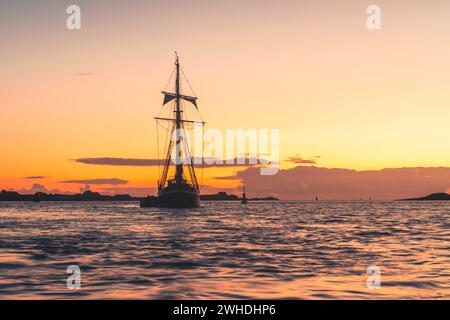 Ein drei-Meister liegt vor der französischen Westküste in der Bretagne bei Sonnenuntergang, warmen Farben, Urlaubsatmosphäre Stockfoto