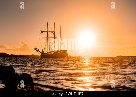 Ein drei-Meister liegt vor der französischen Westküste in der Bretagne bei Sonnenuntergang, warmen Farben, Urlaubsatmosphäre Stockfoto