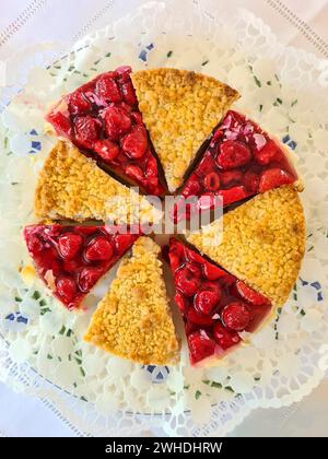 Zwei verschiedene Scheiben Erdbeerkuchen und Käsekuchen auf einem Teller auf einer weißen Tischdecke Stockfoto